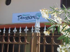 布鲁马迪纽Pousada Tamboril的带有白色花卉和背景标志的栅栏