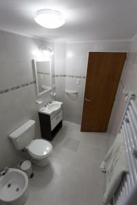 科帕韦Aparthotel Aldea Termal的白色的浴室设有卫生间和水槽。