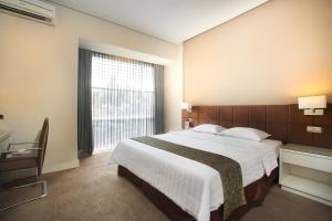 庞卡兰布翁格兰德科库邦酒店的一间卧室设有一张大床和一个大窗户