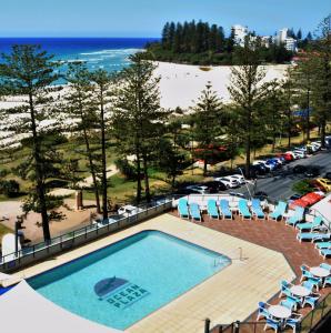 黄金海岸海洋广场度假酒店的一个带椅子的游泳池和海滩