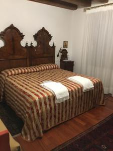 特雷维索达尼诺提农家乐的一间卧室配有一张带条纹毯子的大床