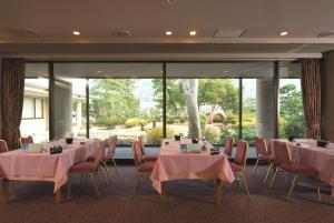沼津沼津哈马宇日式旅馆的一间会议室,配有桌椅和大窗户