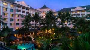 日惹Melia Purosani Yogyakarta的享有棕榈树酒店和庭院的景色