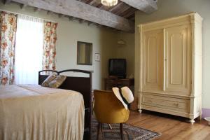 TavoletoPoggio Dei Prugnoli的一间卧室配有一张床、一把椅子和电视