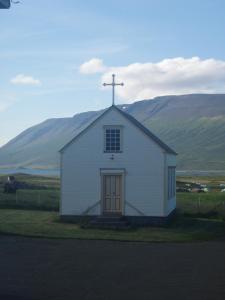 KiðagilLjósavatn Guesthouse的上面有十字架的小白色教堂