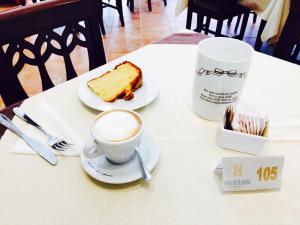 PescinaHotel San Berardo的一杯咖啡和一块蛋糕在桌子上