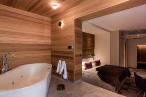卢布尔雅那诺克斯酒店的一间带浴缸的浴室和一张位于客房内的床