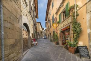 阿雷佐I Bei Ricordi - Historic Centre Apartment 6的老镇里有人坐在长凳上的小巷