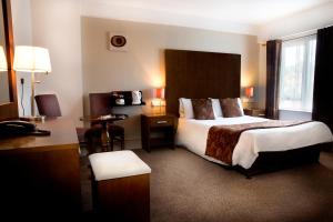 斯温福德盖特威酒店的酒店客房设有一张大床和一张书桌。
