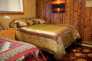 Snow LakeBluenose Bed & Breakfast的木制客房内的一间卧室配有两张床