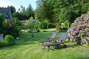 WindfußKleine Stuga的两把长椅和一张野餐桌,位于一个鲜花盛开的院子内