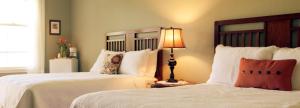 朱利安Julian Lodge的一间卧室设有两张床和一张桌子上的台灯。