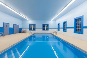 魔鬼湖Super 8 by Wyndham Devils Lake的蓝色墙壁的建筑内的游泳池