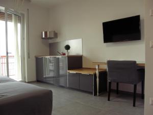 阿夸维瓦德莱丰蒂B&B Via Roma 15的卧室配有桌子和墙上的电视