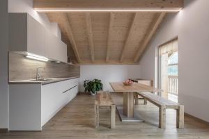 圣卡夏诺Ciasa de Lenz的厨房配有木桌和木板凳