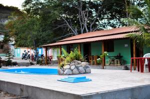 帕尔梅拉斯Pousada Villa Bella的一个带游泳池和房子的度假胜地