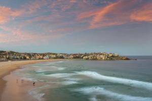 悉尼邦迪海滩村旅舍的和水中的人一起欣赏海滩的景色