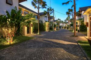 沙努尔沙努尔艺术别墅的棕榈树度假村内一条鹅卵石街道