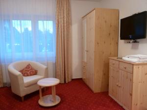 兰河畔马尔堡斯图幕贝勒斯塔尔酒店的酒店客房设有椅子和电视。