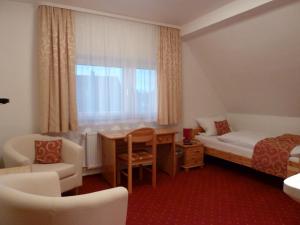 兰河畔马尔堡斯图幕贝勒斯塔尔酒店的配有一张床、一张书桌和一扇窗户的酒店客房