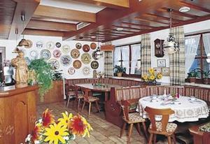 菲利普斯罗伊特Pension Philippsreut "Zum Pfenniggeiger"的一间在房间内配有桌椅的餐厅