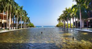 三亚三亚亚龙湾红树林度假酒店（巴厘岛热带风情最佳亲子度假酒店）的一条棕榈树和水池林立的街道