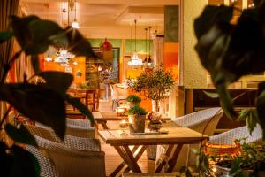 斯坦斯施塔德贝克餐厅和酒店的用餐室配有桌椅和植物
