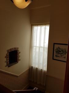 基尔基Myles Creek的窗户配有白色窗帘和壁炉