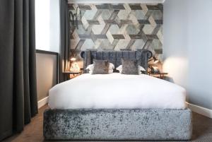 利兹马尔马逊利兹酒店的卧室配有白色的床铺和石墙