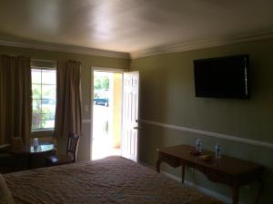 圣安娜圣塔安那旅游酒店的卧室配有一张床,墙上配有电视