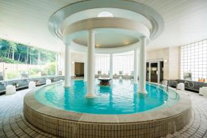 西伊豆町Nishiizu Crystal View Hotel的一座有柱子的建筑中间的游泳池