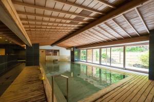 西伊豆町Nishiizu Crystal View Hotel的一座带木制天花板的室内游泳池