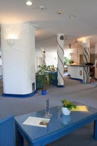Göttlesbrunn高特尔斯布朗赛梅拉酒店的一间设有柱子的房间,配有蓝色桌子