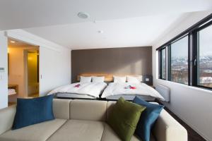 二世古奥尔韦斯雪谷旅馆的一间带两张床和一张沙发的卧室