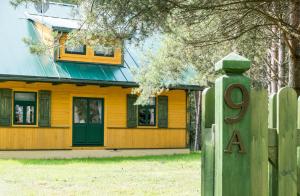 NarewkaWilla Gruszki的黄色的房子,设有绿门和栅栏