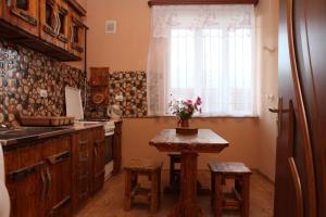 迪利然Guest house Dilijan Orran的厨房配有木桌和窗户。
