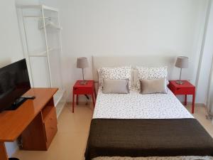 多列毛利诺斯Fan Flat Torremolinos的一间卧室配有一张带两张红色桌子的床