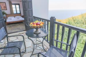 桑加拉达Pilio Sea Horizon Hotel的阳台上的桌子上放着一碗水果