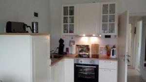 布劳恩拉格Fewo Schröder - Harzflair的厨房配有白色橱柜和炉灶烤箱。