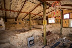 米茨佩·拉蒙萨卡沙漠旅舍的石头建筑中一间配有沙发的房间