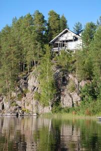 RautalampiRämäkkä Holidays的水体旁山丘上的房屋