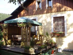 乌帕河畔斯沃博达Pension nad Truhlárnou的房屋设有1个带桌子和遮阳伞的甲板