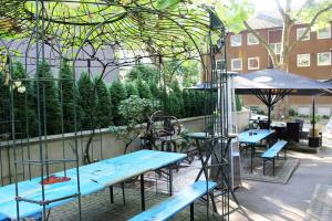 伍珀塔尔奴勒霍夫酒店的庭院配有蓝色的桌椅和遮阳伞。