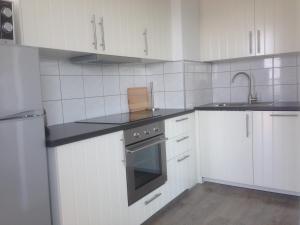 奥斯坦德Apartment Raversijde with Seaview的白色的厨房设有水槽和炉灶。