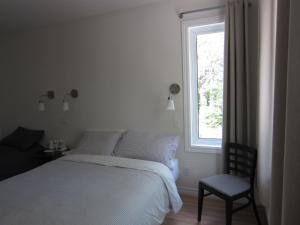 翁弗勒Auberge Île du Repos的卧室配有床、椅子和窗户。