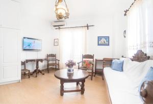 米克诺斯城New Mykonos town house的客厅配有沙发、桌子和钢琴