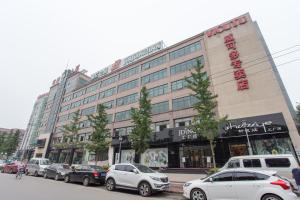 大兴锦江之星北京大兴开发区店的一座大型建筑,前面有汽车停放