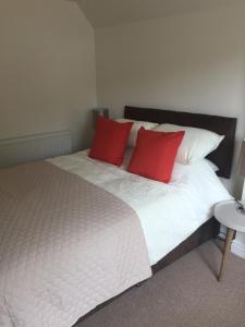 温福德铜币住宿加早餐旅馆的一间卧室配有一张带两个红色枕头的床