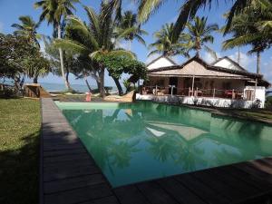 圣玛丽Hotel Club Paradise的棕榈树屋前的游泳池