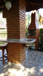 卢米亚Casa Temporada em Lumiar的砖墙,砖炉旁有石桌